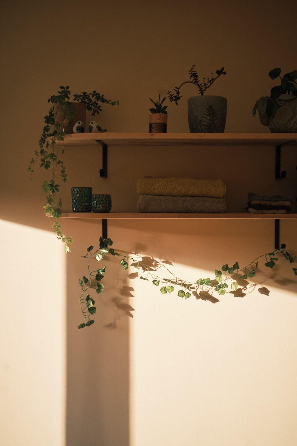 A view of the cocon jaune massage room, with a massage table in the middle, a lamp hanging above and a window behind it.